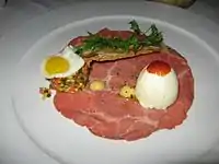 牛肉のカルパッチョ、うずら卵、デビルド・エッグ、サルピコンからなるユニークなステーキ・アンド・エッグ