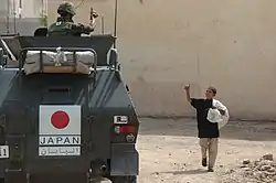 挨拶を交わすイラク少年と戦争後の復興支援する軽装甲機動車の隊員