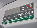 車内のステッカー。下の緑のラベルに「この電車は、従来の半分以下の電力で走っています」との表記がある（2011年1月3日 武蔵野線）