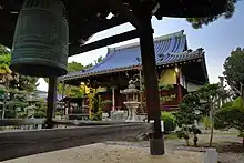 佐井寺の現在の本殿（奥）と、府内で２番目に古いとされる鐘楼（手前）