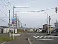 北海道道935号小黒部鰔川線・終点と国道229号の交差点部（乙部町側から）、片持式（オーバーハング式）標識柱は以前に大型車両規制の「指定方向外進行禁止」とその補助標識が取り付けられていた