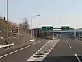 外部照明方式(遠方照明方式)を用いたジャンクション分岐部直前の「方面及び方向(108の2-E)」標識の例(道央自動車道 北海道千歳市)