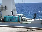 だいとうにクレーンで積まれる軽自動車