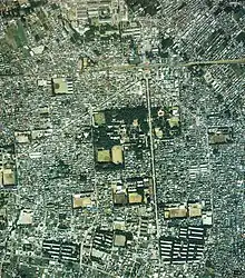 航空写真。上部に駅、その下に放射状に伸びる道路や一橋大学が見える。国土交通省 国土地理院 地図・空中写真閲覧サービスの空中写真を基に作成
