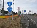国道230号・国道5号との重複区間を示す標識、奥側に重複路線表示の案内標識・方面及び距離(106-A)(長万部町中の沢、2019年3月撮影)