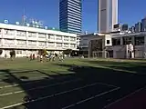 南側公道から校庭と校舎の北東を見る（2015年1月撮影）