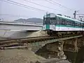 架け替え前の吉田川橋梁と小型車両の600形電車。（2004年）
