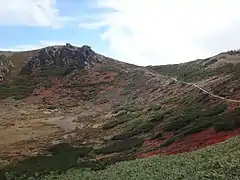 新本白根火砕丘の火口。左の岩の周辺が本白根山展望所。