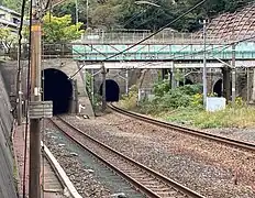 東山隧道下り外側線東口坑口(中央左)と北花山第2跨線橋(水色柵の鋼橋)