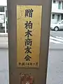 深堀町停留場に設置の時計に付けられた、寄贈者と寄贈年月が書かれた銘板（2017年4月撮影）