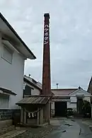 白牡丹延宝蔵煙突。大正期の建設。手前は延宝井戸。国の登録有形文化財。
