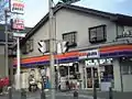 1993年・平成5年のスリーエフが向陽台地区で初出店のコンビニであった。場所は向陽台郵便局のやや百村寄り手前に位置していたが、その後、画像のam/pmに転換し閉店。2024年現在は歯科医院となっている(画像は2004年12月撮影)。
