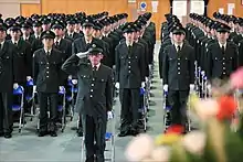 「頭中」の敬礼。指揮官は挙手の敬礼、他の隊員は鼻先や顎から顔を執行者に向けて注目