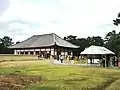 仮金堂（現・仮講堂）と再建前の中金堂基壇（左）