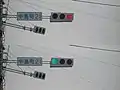誤認防止のためレンズの発散角度を制限させたLED信号機1（2枚合成、上：赤、下：青）、角度を変えると正対する信号以外は灯火が見えなくなる