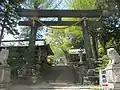 諏訪大社前宮鳥居（左手に案内板、供養塔は登って右側）