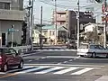 菅原神社交差点（拡幅前）。東京都道18号府中町田線は左奥から来て、右から来る東京都道・神奈川県道3号世田谷町田線バイパスと合流する