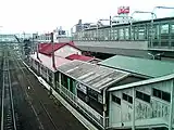 跨線橋より見た旧駅舎。右上に見えるのが建設中の高架ホーム（2006年6月）