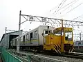 牽引車に牽引される07-203と07-303画面中央に見える手動転轍器は工場内での車両入換えに使用される。