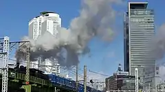 名駅のビル群とあおなみ線を走るC56形蒸気機関車（2013年2月）