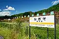 駅名標と駅裏の材木置き場
