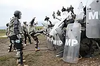 コソボ派遣中、暴動鎮圧訓練において暴徒役を演じるノースカロライナ陸軍州兵。阻止線を張っているのはポーランド軍兵士。