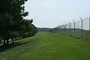 現代の空港まわりの金属製の柵(フェンス)。侵入者を防ぐために上部に有刺鉄線も備える。