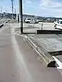 東武矢板線の遺構と思われる不自然なコンクリートブロックと奥は画像にある橋台へと続く整地された旧路盤跡(未使用)。(撮影場所)