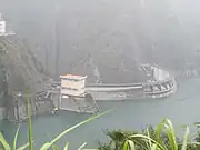 左: 水庫の排水トンネル口設備。右: 取水口とダム堤頂部。