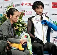 2011年ロステレコム杯のキス・アンド・クライにて阿部奈々美とともに得点を待つ羽生結弦