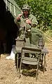 つなぎのM1943HBT作業服を着て戦車兵用ヘルメットを被るイベント参加者(2018年ゼントハイム(フランス語版)での歴史再現イベント)