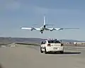 着陸するER-2と並走する支援車両（3代目ダッジ・チャージャー）