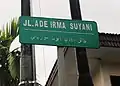 インドネシアのリアウ州・プカンバルにある道路名を記した標識。「アデ・イルマ・スルヤニ通り」(JL. Ade Irma Suyani)というインドネシア語の名称がジャウィ文字とラテン文字で併記されている(2013年撮影)。