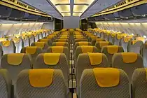 A310-300のエコノミークラスの客室内を前方から見た写真。2本の通路を挟んで2-4-2の配置で黄色い座席が並んでいる。