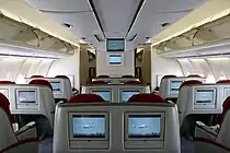 ビジネスクラスの客室内を後方から見た写真。2本の通路を挟んで2-2-2の配置で座席が並んでいる。