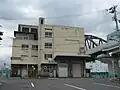 安治川トンネルエレベーター塔の建物（南側）。右端の高架橋は阪神なんば線安治川橋梁。2009年7月撮影