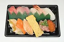 持ち帰り用の容器に詰めた寿司（タッチパネルなどで注文できる）