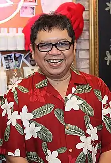 眼鏡をかけた丸顔の男性。