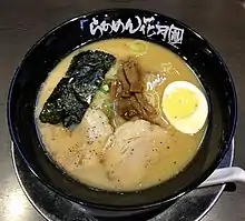 漆黒のラーメン鉢と、白い筆文字のロゴタイプが、ブランドを強く主張しています。