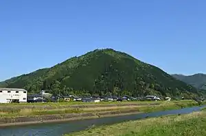 有子山全景山頂に石垣、左山麓に出石城。手前は出石川。