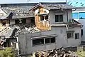 被害を受けた民家。窓、屋根、壁などに被害を受けている