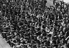 1936年6月、ハンブルクの進水式でナチス式敬礼を行う人々と、ただ一人行わなかったアウグスト・ランドメッサーの写真