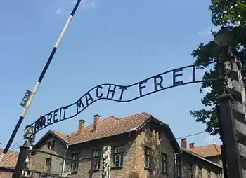「ARBEIT MACHT FREI（ドイツ語で働けば自由になるの意味）」と記された、第一強制収容所の門のアーチ。「B」のプレートのみ明らかに上下逆に付けられているが、一説には、設置作業にあたった収容者がせめてもの抵抗として、上下逆に取り付けたと言われる。