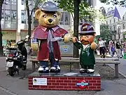 ホームズの格好をしたクマの人形（左）。えんじ色のインバネスコートを身につけている。