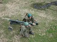 移動状態のAG-9(ルーマニア製SPG-9)三脚に車輪が付いている奥の射手が持つコンテナには照準器が収納されている