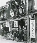 新築落成の記念大売り出し(1912年(明治45年))。カンカン帽をかぶっているのが六代目の主人。