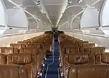 客室内を前方から見た写真。通路を挟んで左右に座席が配置されている。手前側が2+2の4アブレスト、奥が3+2の5アブレストである。