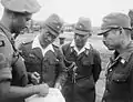 1945年、シンガポールにてイギリスインド軍少佐（第5インド師団）と写る陸軍少将（第7方面軍参謀副長志村文雄、右端）および陸軍大佐（中央右）。中央左は従軍服を着用した通訳担当の陸軍軍属高等官（奏任官七等）