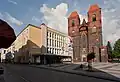 ポーランドのブジェク市の建物2軒。15世紀の教会（右）と1926年の市民文化会館（左）。