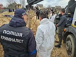 ロシア軍撤退後のブチャにおいて、虐殺事件の現場検証を行う警察官。
